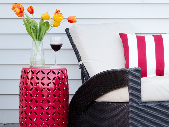 Small side table with flowers sitting next to a patio chair.